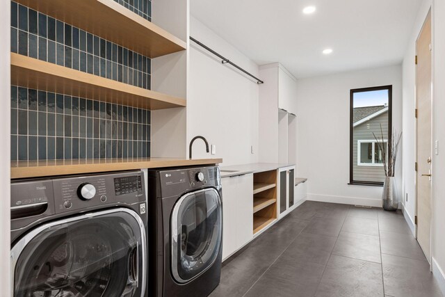 washroom featuring laundry area, baseboards, washer and clothes dryer, dark tile patterned floors, and recessed lighting