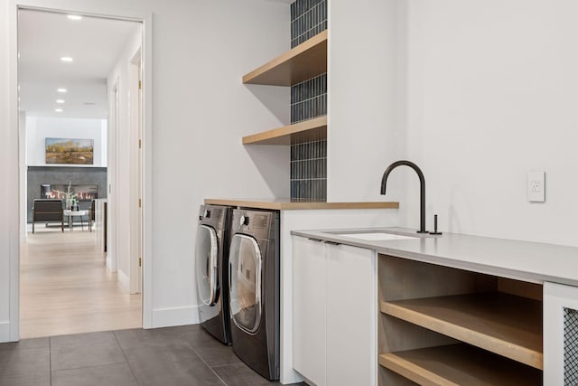 laundry room with recessed lighting, a sink, washer and dryer, laundry area, and dark tile patterned floors