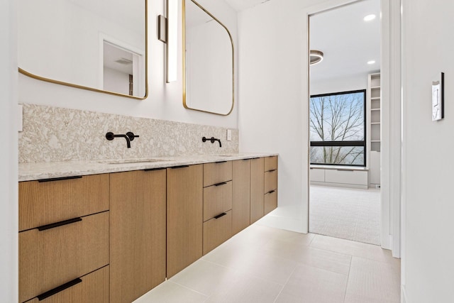 bathroom with tasteful backsplash, a sink, and double vanity