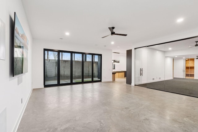 unfurnished living room featuring a ceiling fan, recessed lighting, and concrete floors