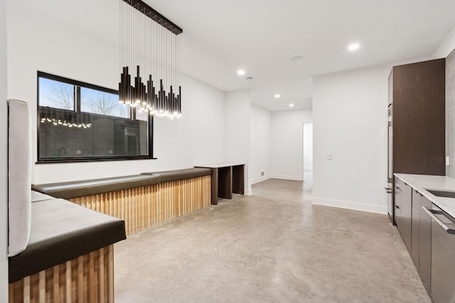 bar with baseboards, dishwasher, concrete floors, a sink, and recessed lighting