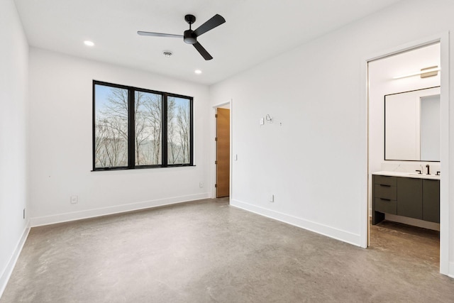 unfurnished bedroom featuring baseboards, ensuite bathroom, finished concrete floors, a sink, and recessed lighting