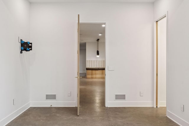 unfurnished room featuring baseboards, visible vents, and finished concrete floors