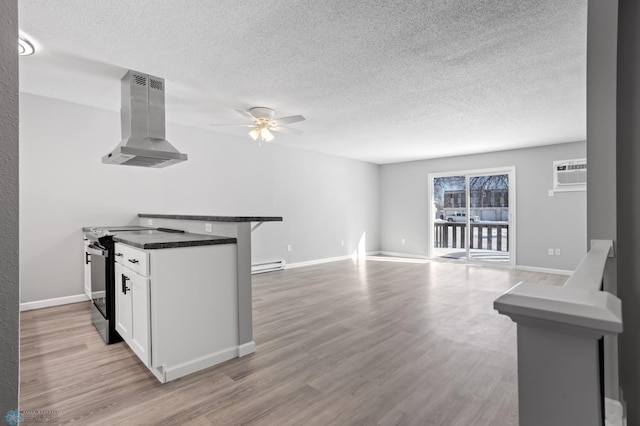 kitchen featuring white cabinetry, island range hood, a wall mounted AC, range with electric stovetop, and light hardwood / wood-style floors