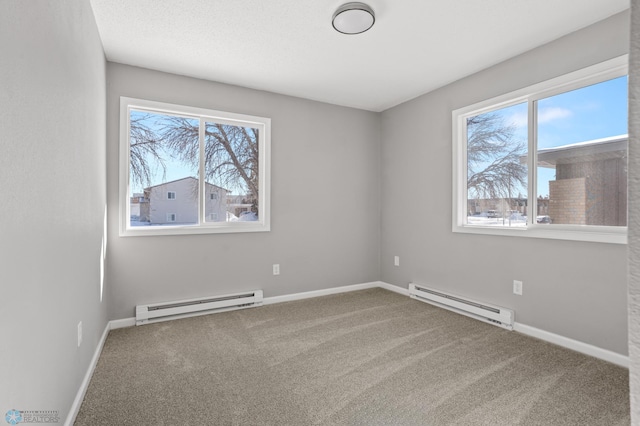 carpeted empty room with a wealth of natural light and a baseboard heating unit