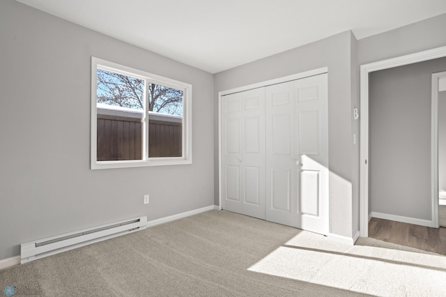 unfurnished bedroom with a baseboard heating unit, light carpet, and a closet