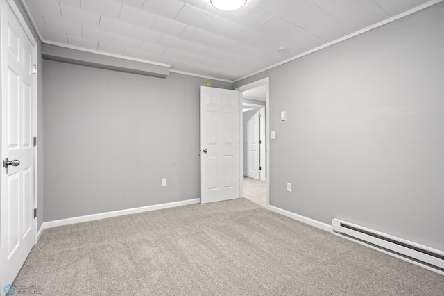 carpeted spare room with ornamental molding and a baseboard heating unit