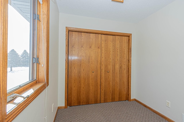 interior space with carpet floors, a closet, and a textured ceiling