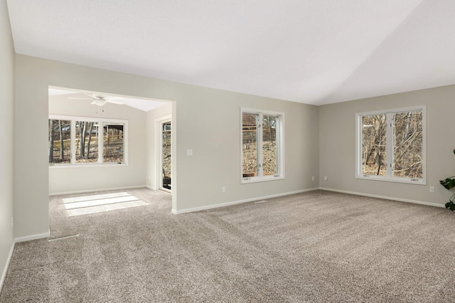 empty room featuring baseboards, carpet, and vaulted ceiling