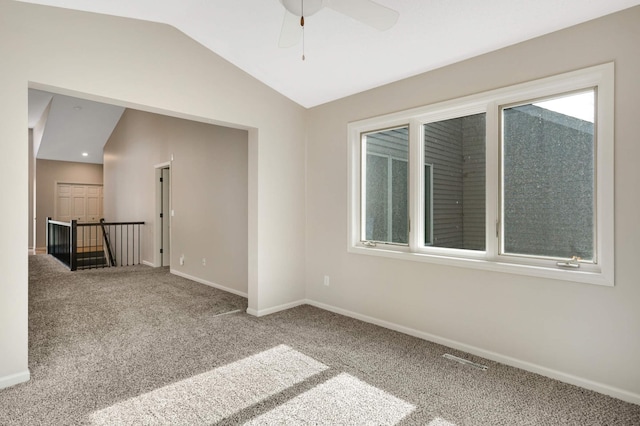 spare room with lofted ceiling, carpet flooring, visible vents, and baseboards