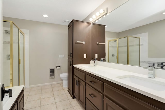 bathroom with visible vents, a shower stall, toilet, heating unit, and a sink