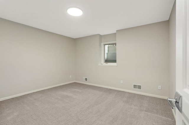 carpeted spare room featuring visible vents and baseboards