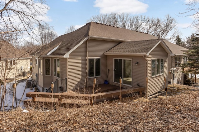 rear view of house with roof with shingles