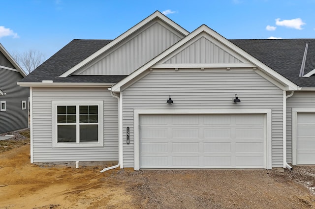 view of front of home featuring driveway, a shingled roof, a garage, and board and batten siding