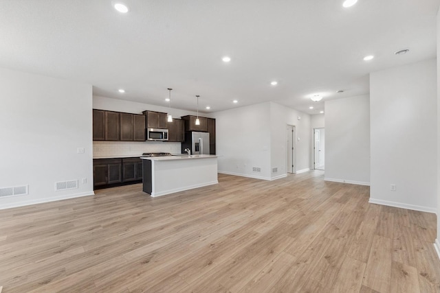 kitchen with dark brown cabinetry, visible vents, open floor plan, and appliances with stainless steel finishes