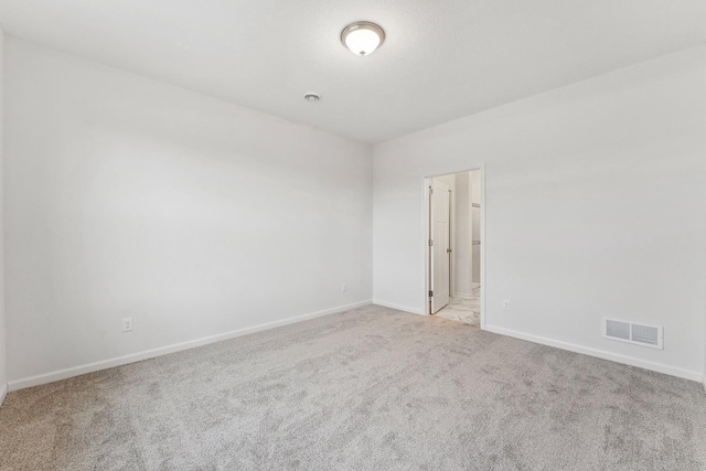 unfurnished room with visible vents, carpet floors, and baseboards