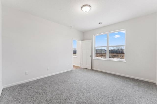 unfurnished room featuring baseboards and carpet