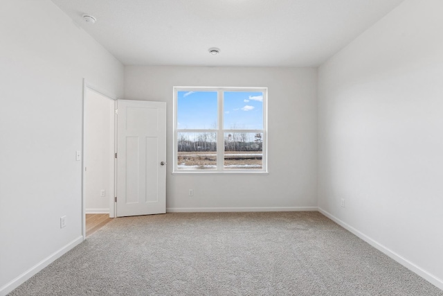 carpeted spare room featuring baseboards