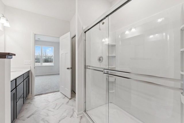 full bath with vanity, marble finish floor, and a shower stall