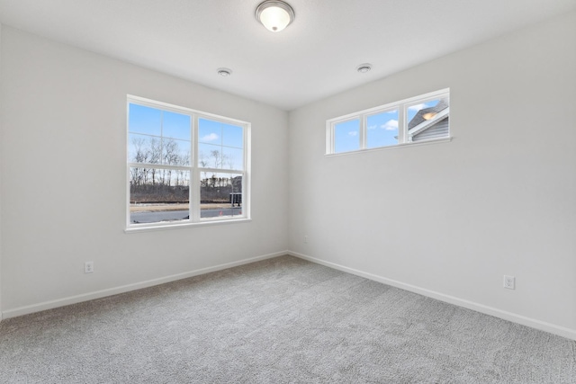 carpeted empty room featuring baseboards