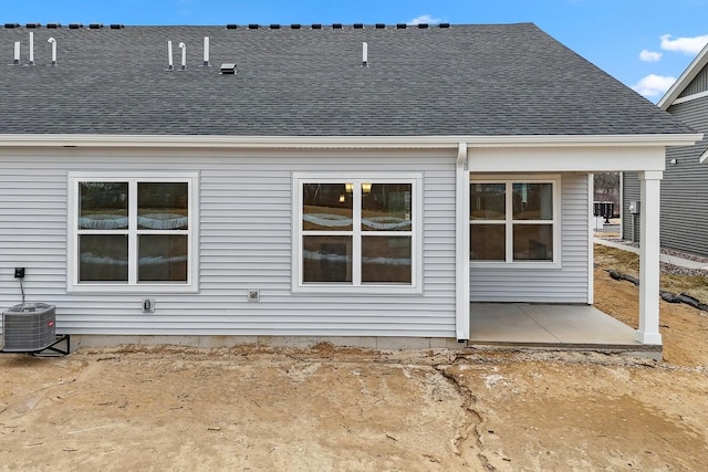 back of house featuring a patio, roof with shingles, and central AC