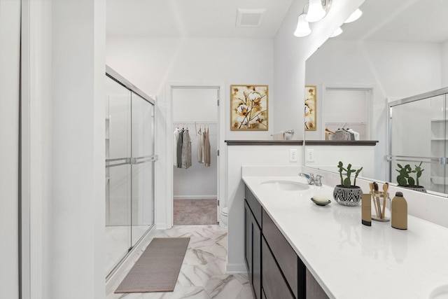 bathroom with a shower stall, marble finish floor, and a sink