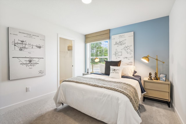 carpeted bedroom featuring a walk in closet