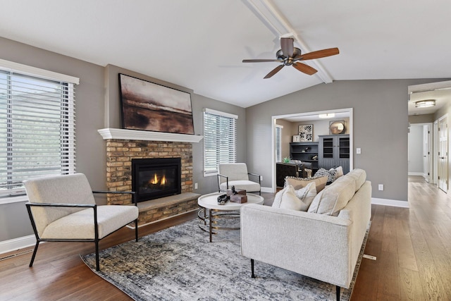 living room featuring hardwood / wood-style floors, a fireplace, lofted ceiling with beams, and ceiling fan