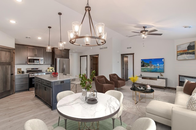 dining space featuring vaulted ceiling, ceiling fan, and light wood-type flooring