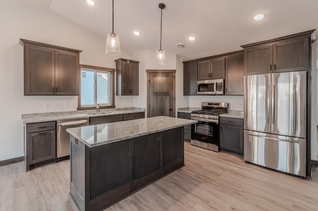 kitchen featuring a kitchen island, decorative light fixtures, sink, stainless steel appliances, and dark brown cabinets