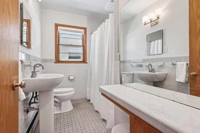 bathroom featuring tile walls, sink, and toilet