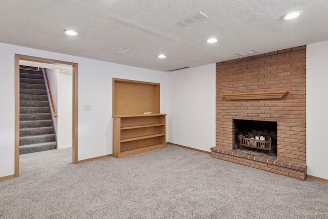 unfurnished living room featuring a fireplace, a textured ceiling, and carpet