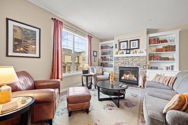 living room with built in shelves, a fireplace, and a textured ceiling