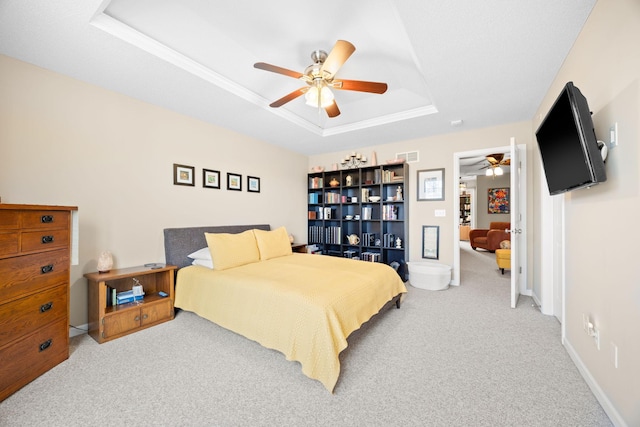 carpeted bedroom with a tray ceiling, baseboards, visible vents, and ceiling fan