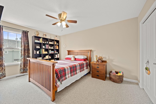 carpeted bedroom with baseboards, a closet, and ceiling fan