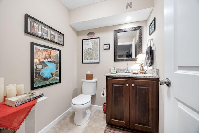 bathroom with tile patterned floors, toilet, vanity, and baseboards