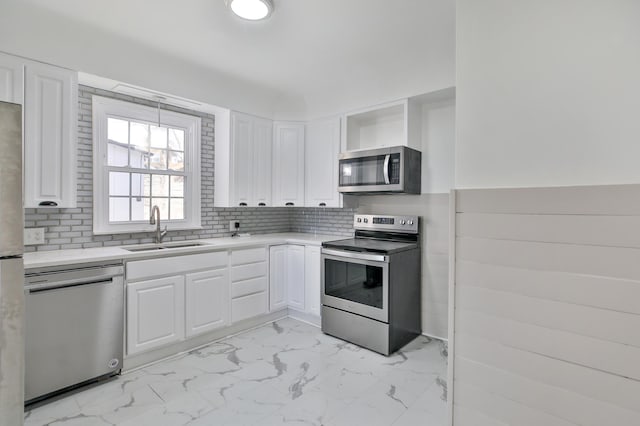 kitchen featuring white cabinetry, sink, tasteful backsplash, and stainless steel appliances