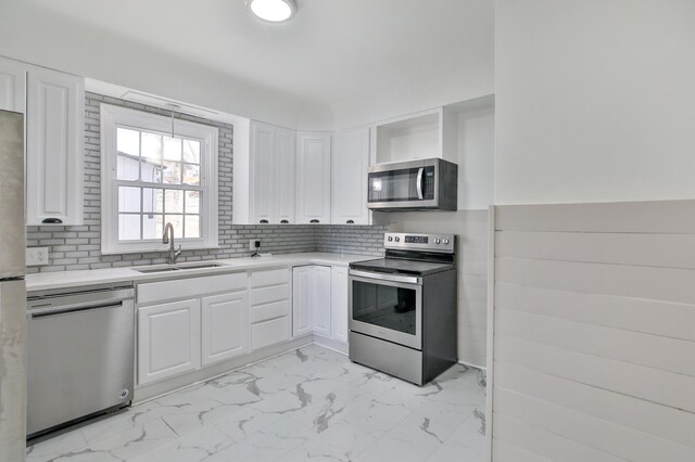 kitchen featuring a sink, white cabinets, marble finish floor, appliances with stainless steel finishes, and light countertops