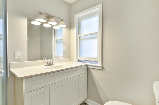half bath featuring vanity, toilet, and baseboards