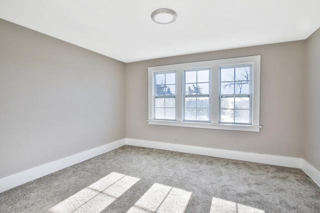 carpeted empty room with baseboards