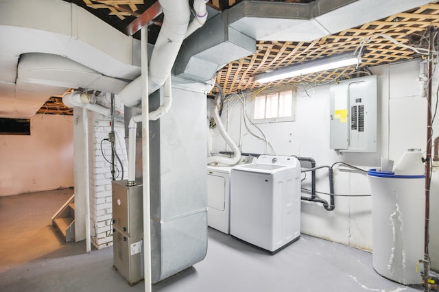 below grade area featuring heating unit, electric panel, and washer and clothes dryer