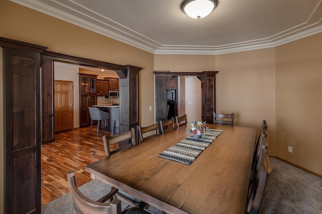 dining space with crown molding and dark wood-type flooring