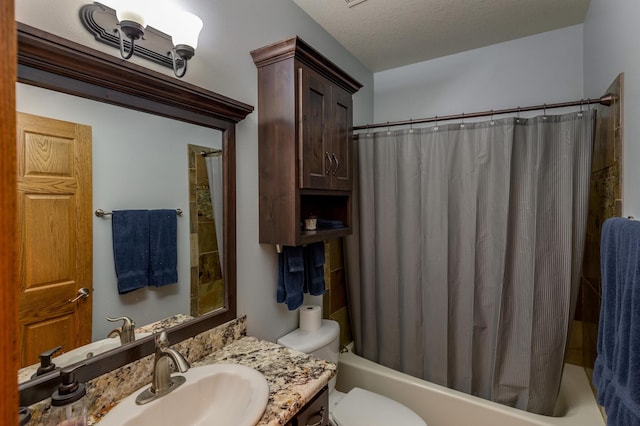 bathroom with vanity, toilet, and a textured ceiling