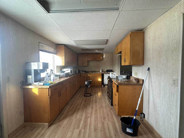 kitchen with a paneled ceiling, electric range, and light wood-type flooring