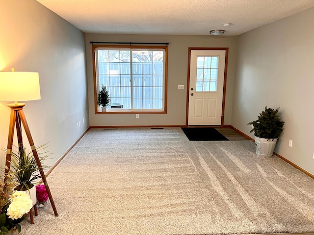 doorway with carpet flooring and a textured ceiling