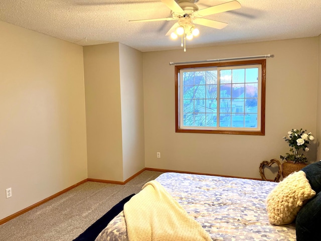 bedroom featuring carpet, ceiling fan, and a textured ceiling