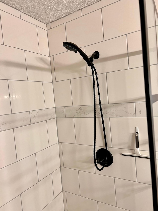 room details with a tile shower and a textured ceiling