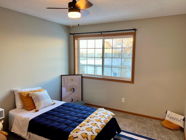 bedroom featuring ceiling fan, carpet floors, and a textured ceiling