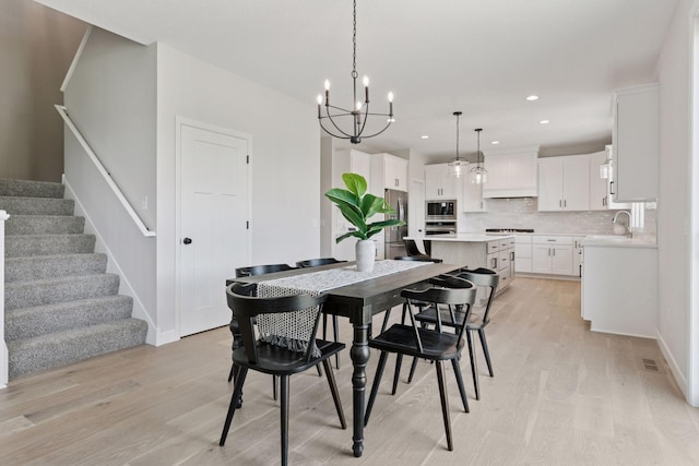 17953 Hidden Creek Trl, Lakeville, MN 55044 - dining space with light wood finished floors, a chandelier, stairs, and recessed lighting
