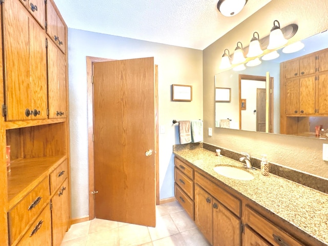 bathroom featuring vanity, a textured ceiling, and tile patterned flooring